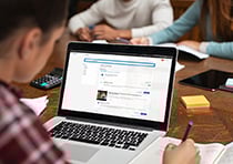 Person looking at Teach Cambridge on a laptop